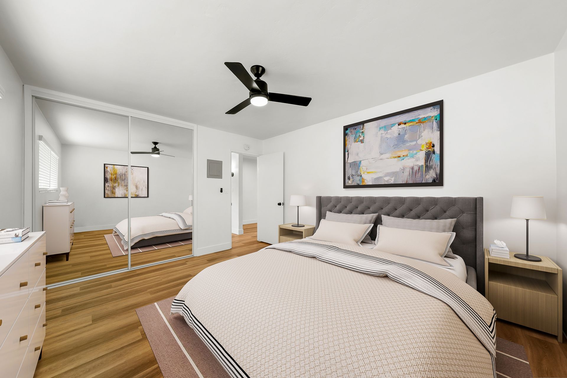 A bedroom with a large bed and a ceiling fan.