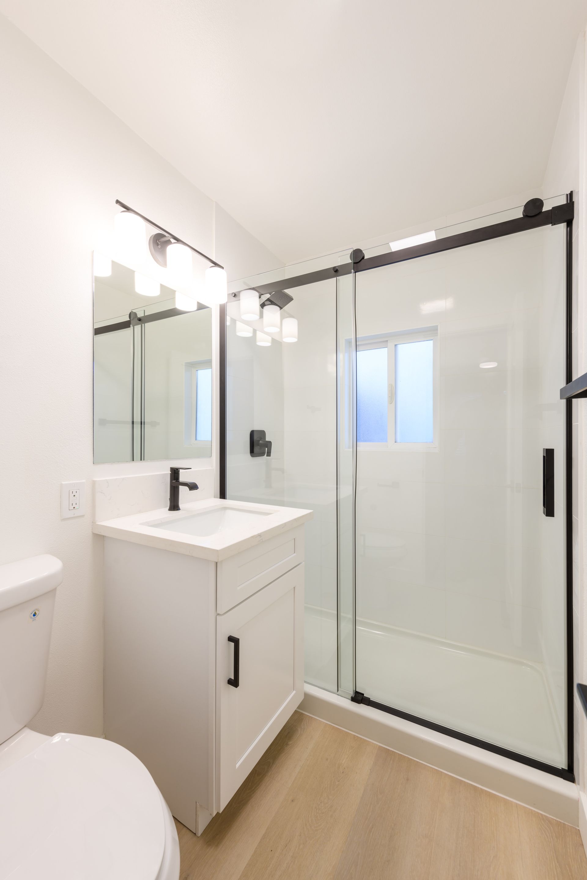 A bathroom with a toilet , sink , and shower.