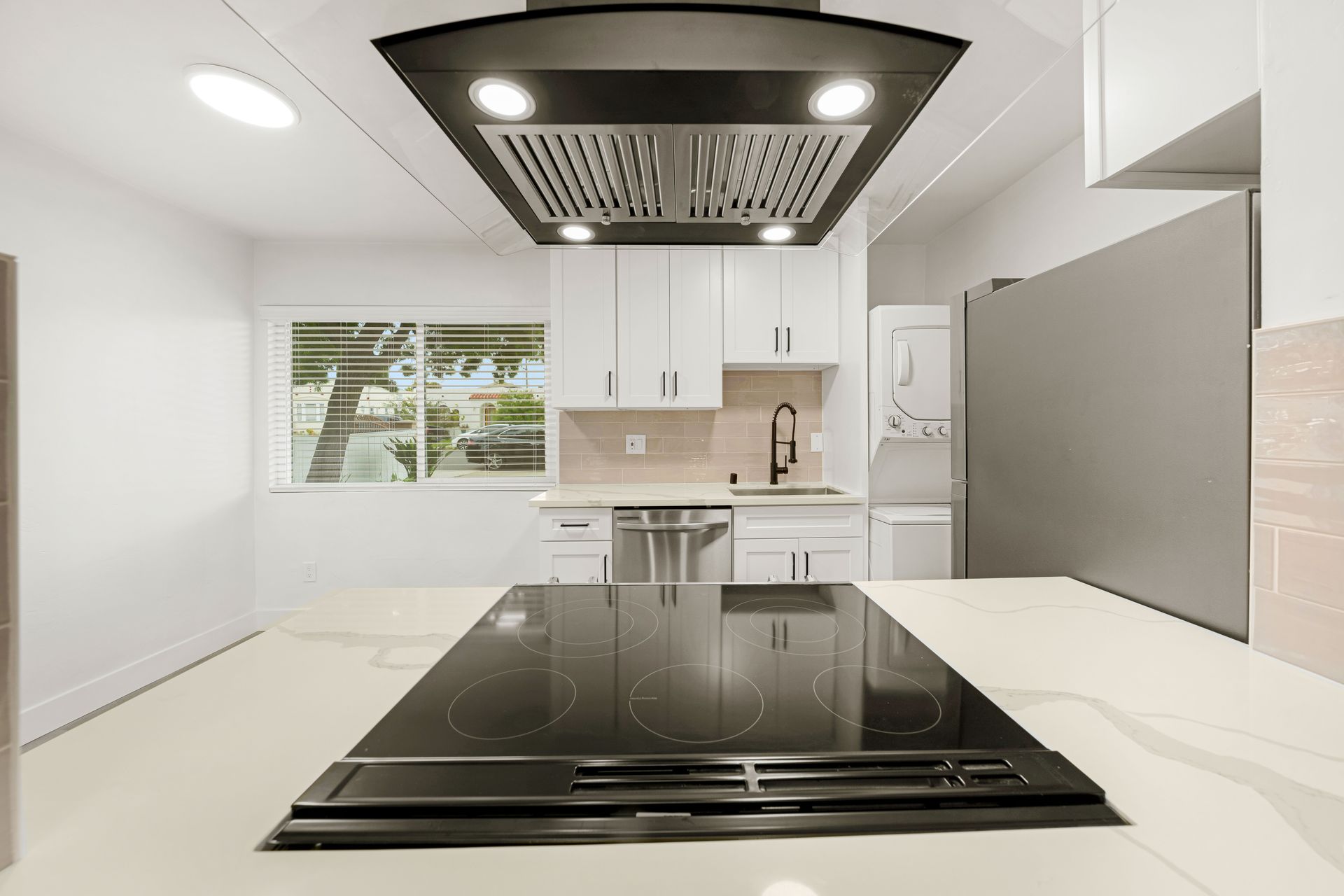 A kitchen with a black stove top oven and white cabinets.