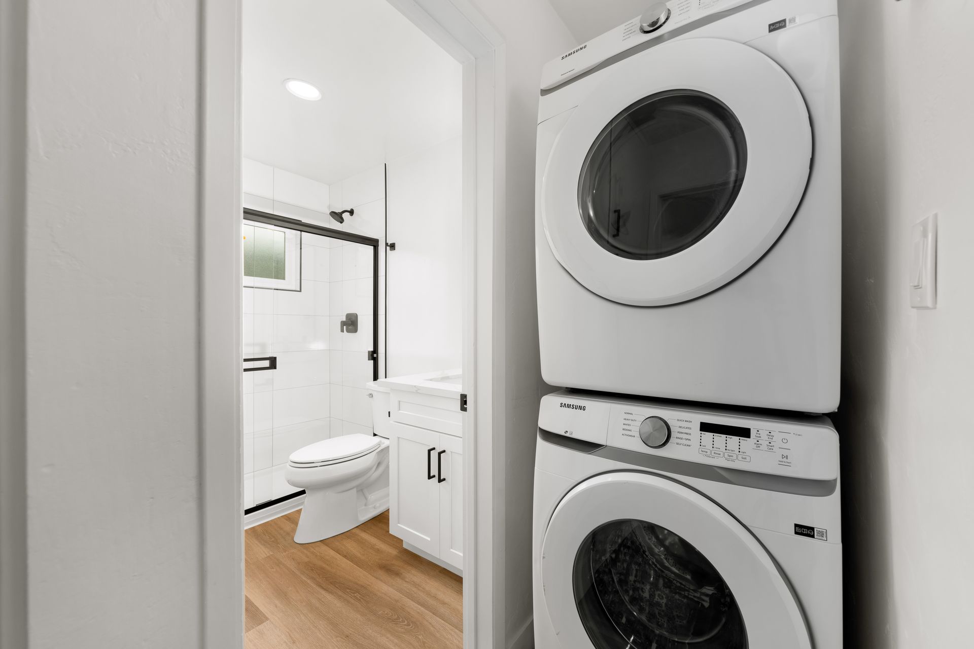 A washer and dryer are stacked on top of each other in a bathroom.