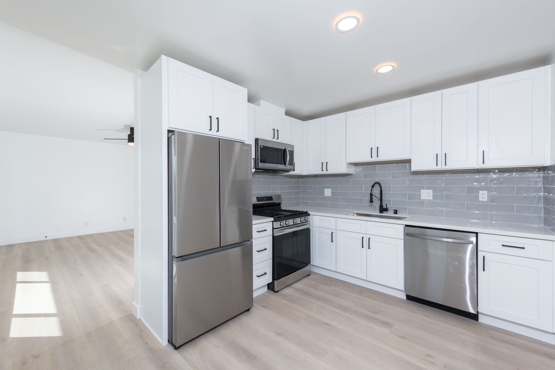 A kitchen with white cabinets and stainless steel appliances