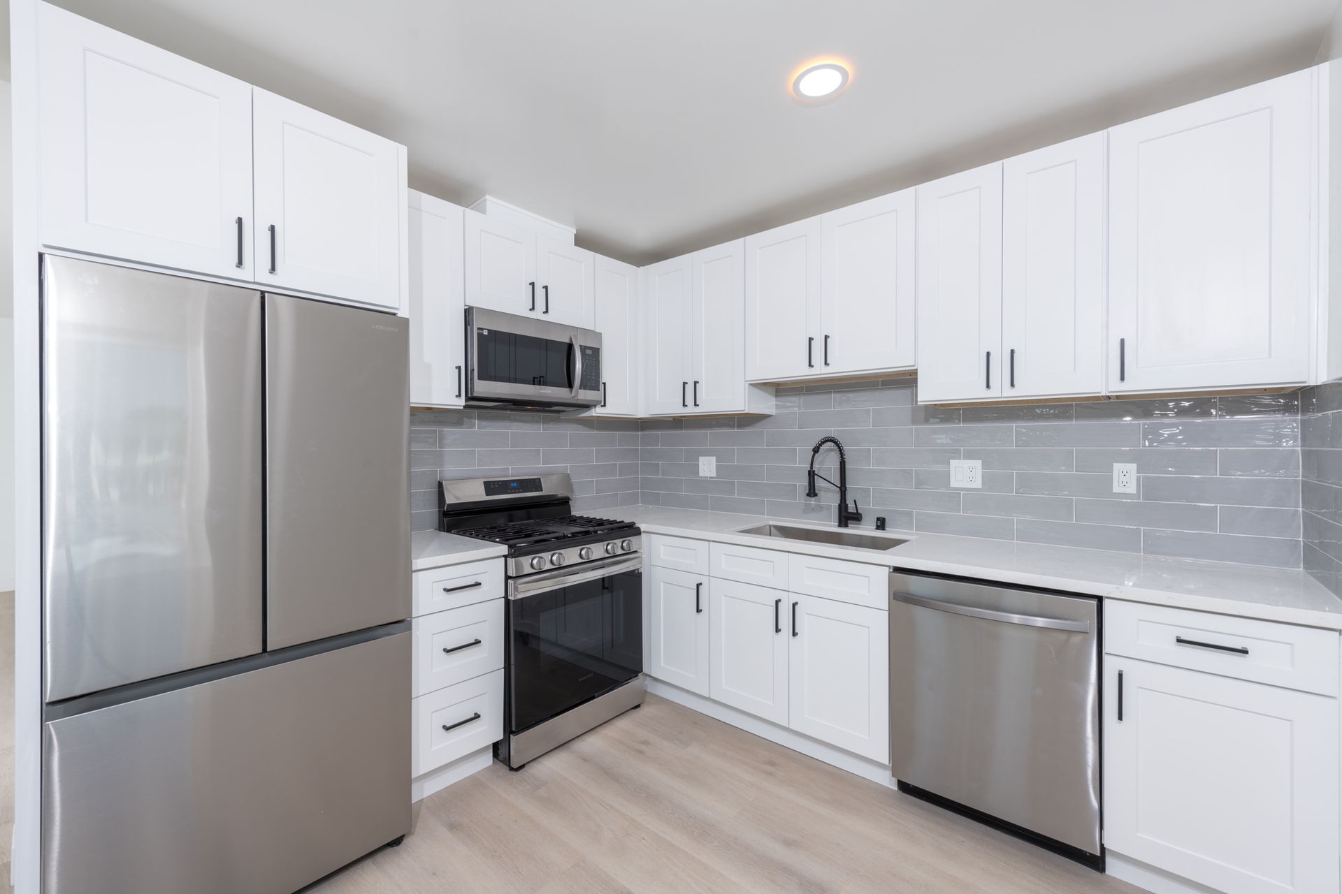 A kitchen with white cabinets and stainless steel appliances.