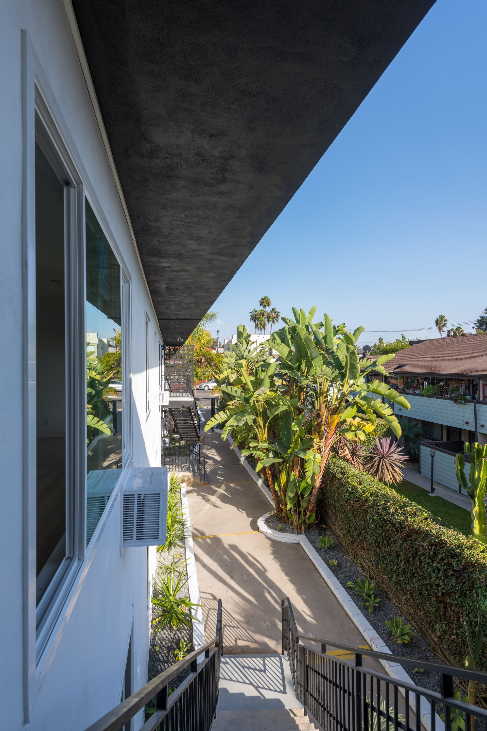 A view of a building from a balcony with stairs leading up to it.