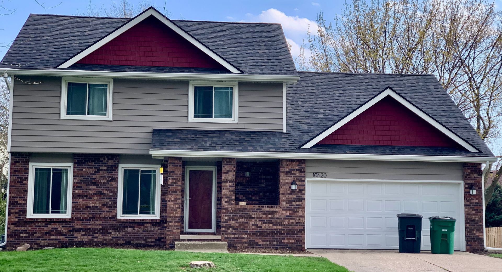 A large house with a red roof and a white garage door.
