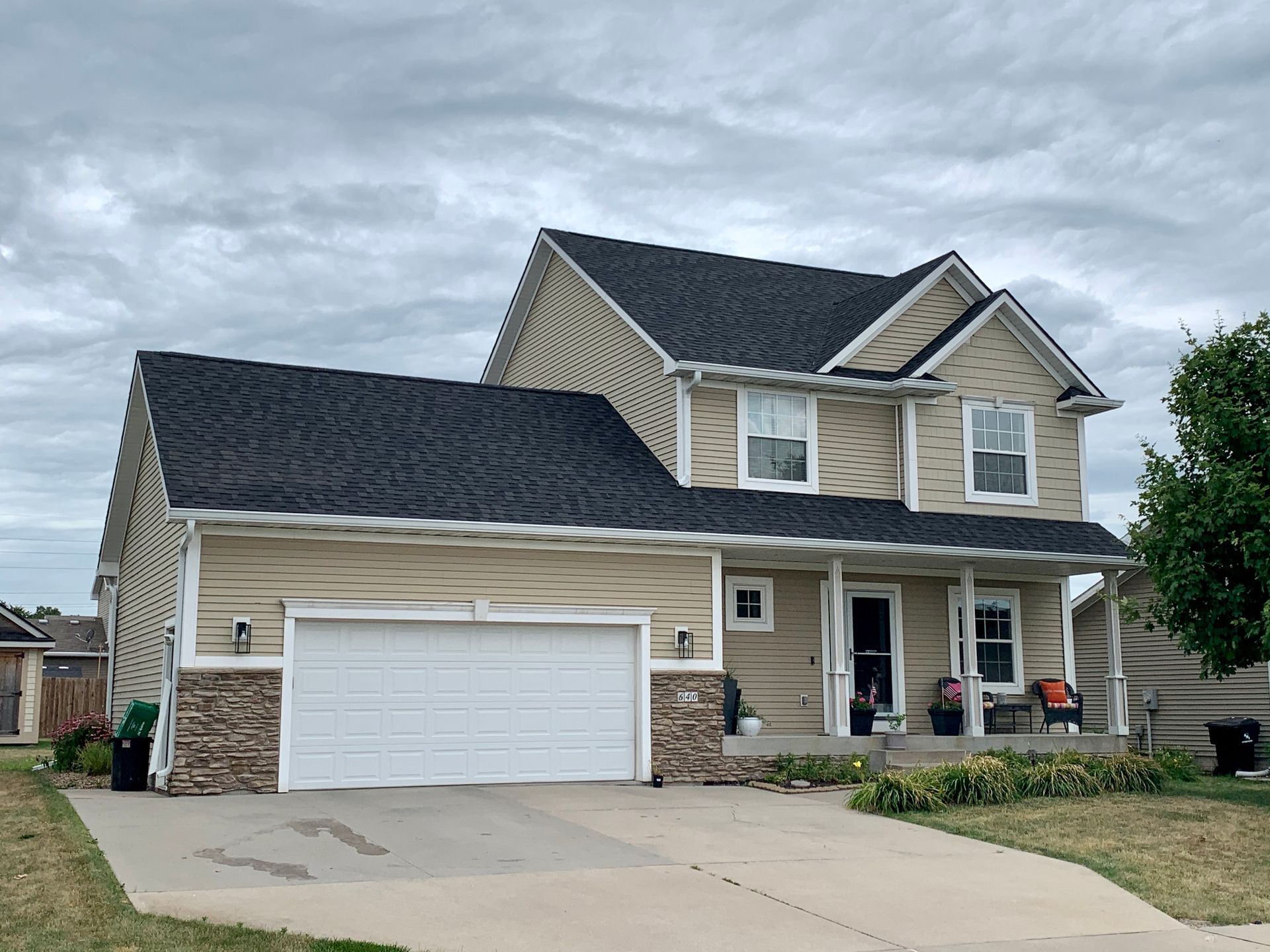 A large house with a black roof and a white garage door.