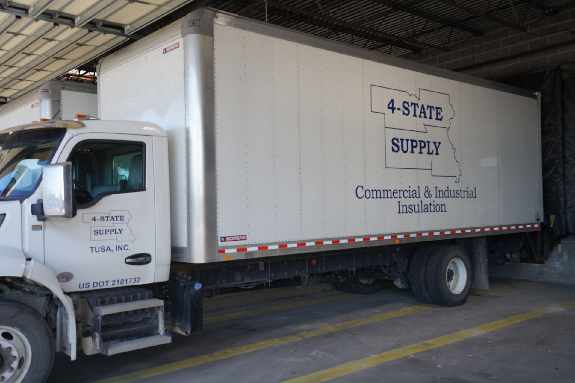 White 4-State Supply truck at a loading dock, with commercial and industrial insulation branding.