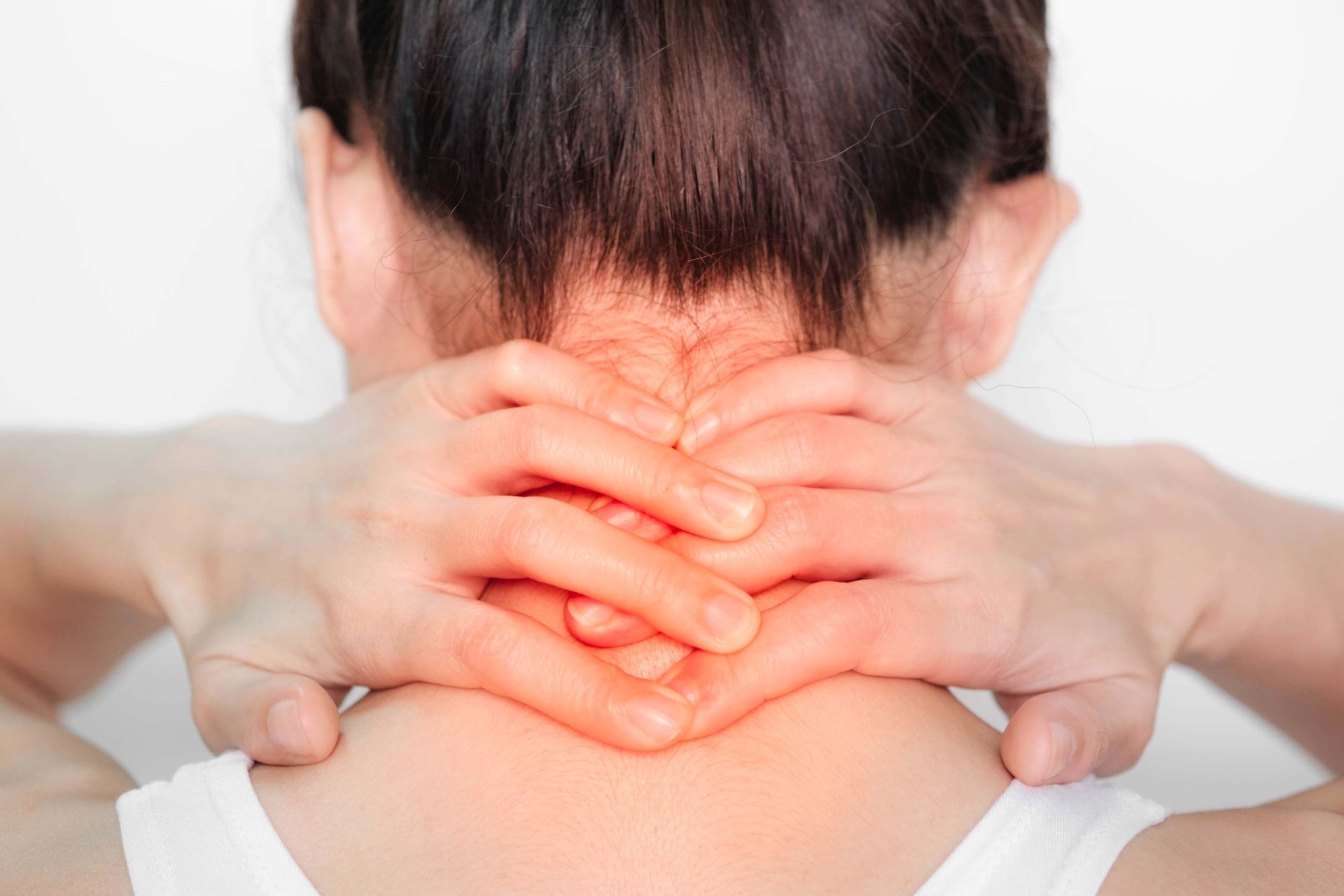 Woman holding her neck in pain, red highlighting where she is touching.