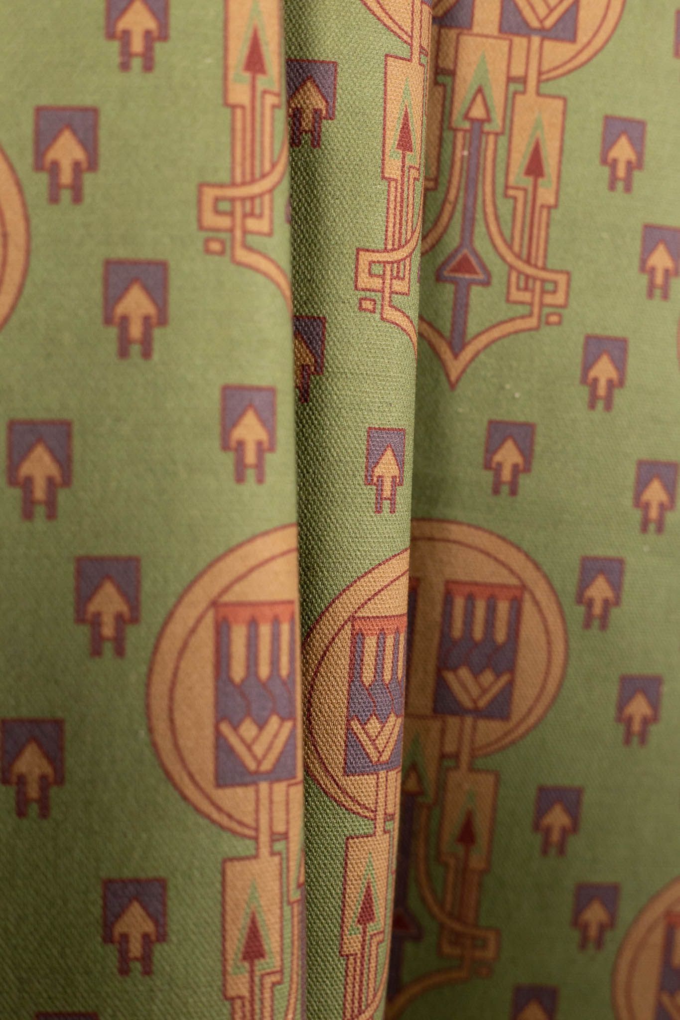 A close up of a green curtain with arrows on it