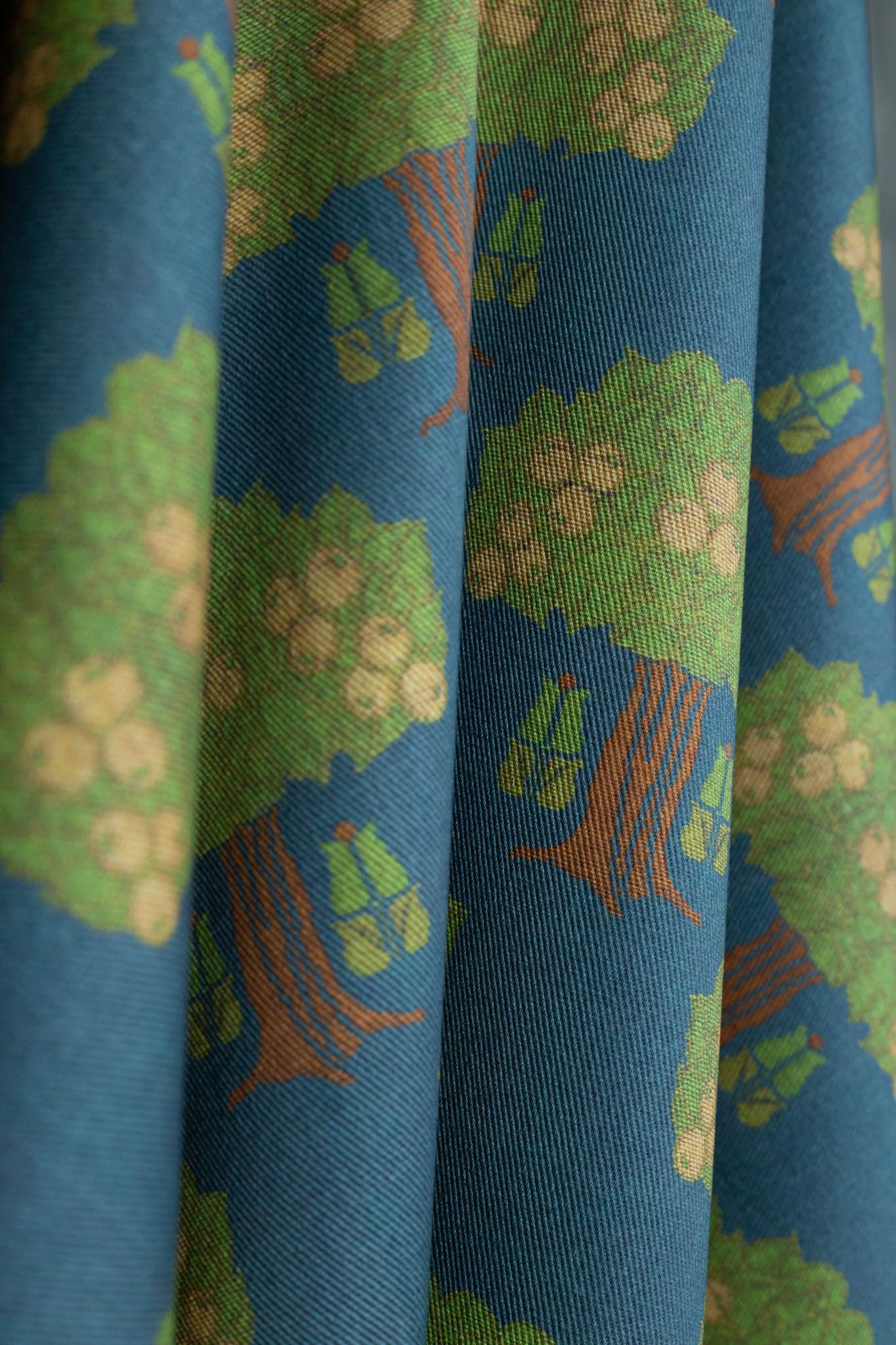 A close up of a piece of fabric with a pattern of trees on it.