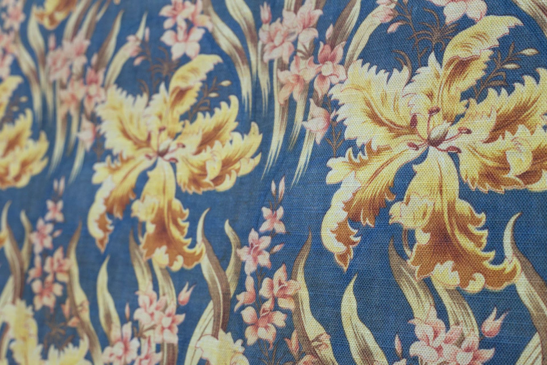 A close up of a blue and yellow floral fabric.