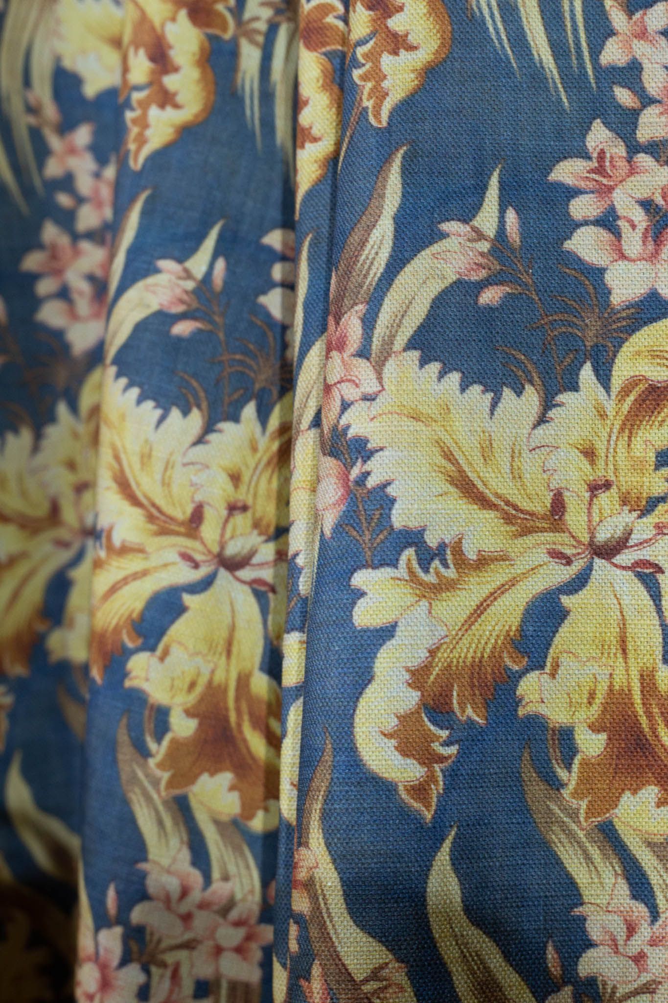 A close up of a blue and yellow floral fabric.