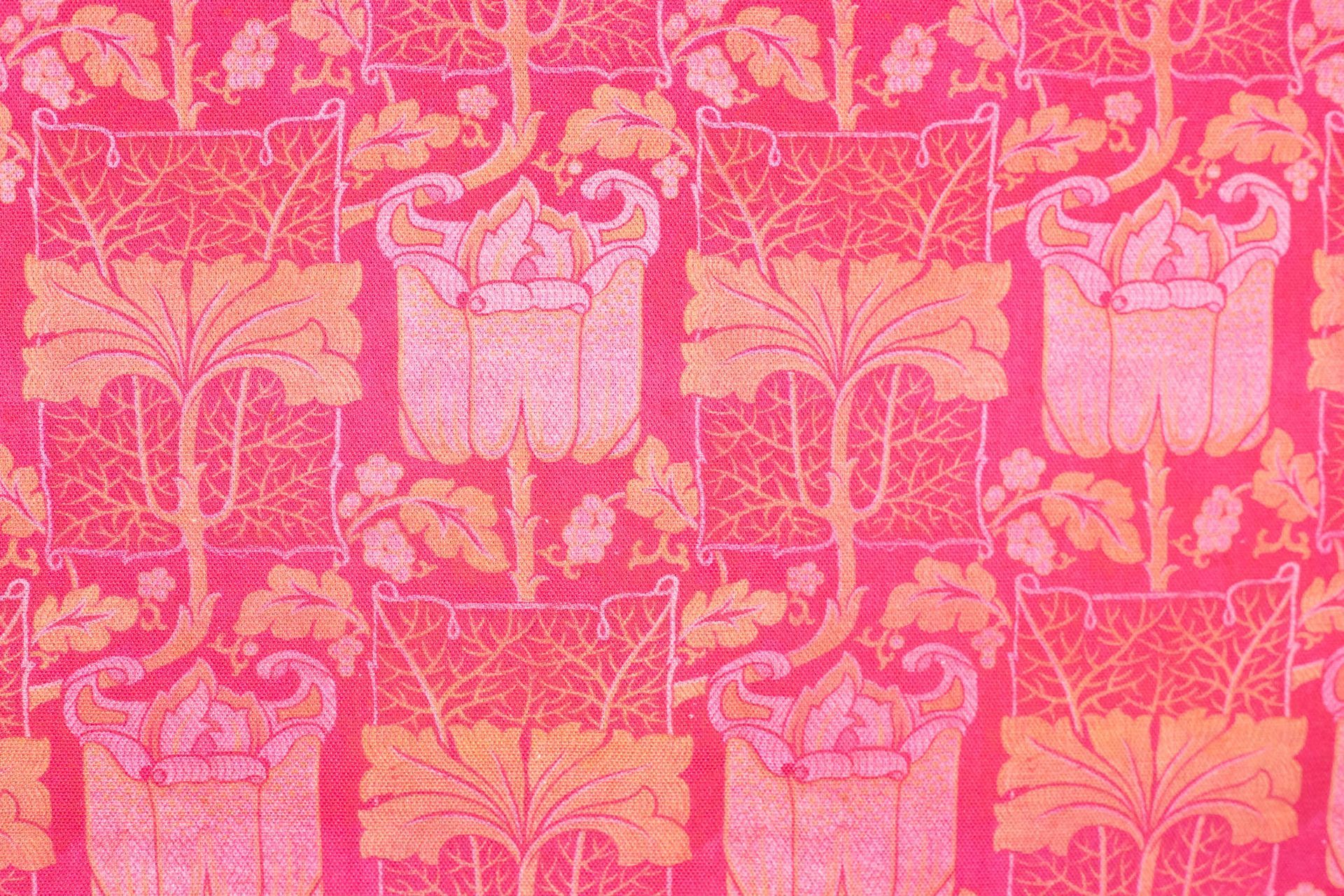 A close up of a pink and yellow curtain with a pattern on it.