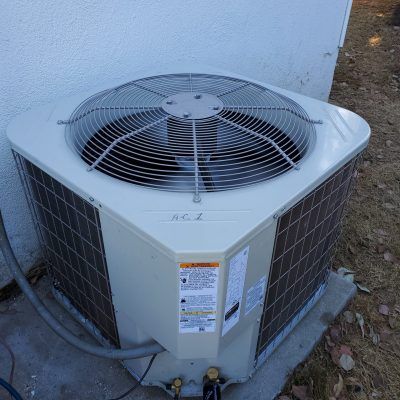 An ac unit is sitting on the side of a building