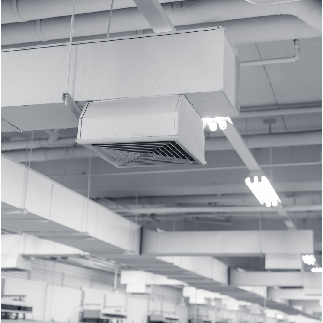 A black and white photo of a ceiling with a lot of pipes hanging from it.