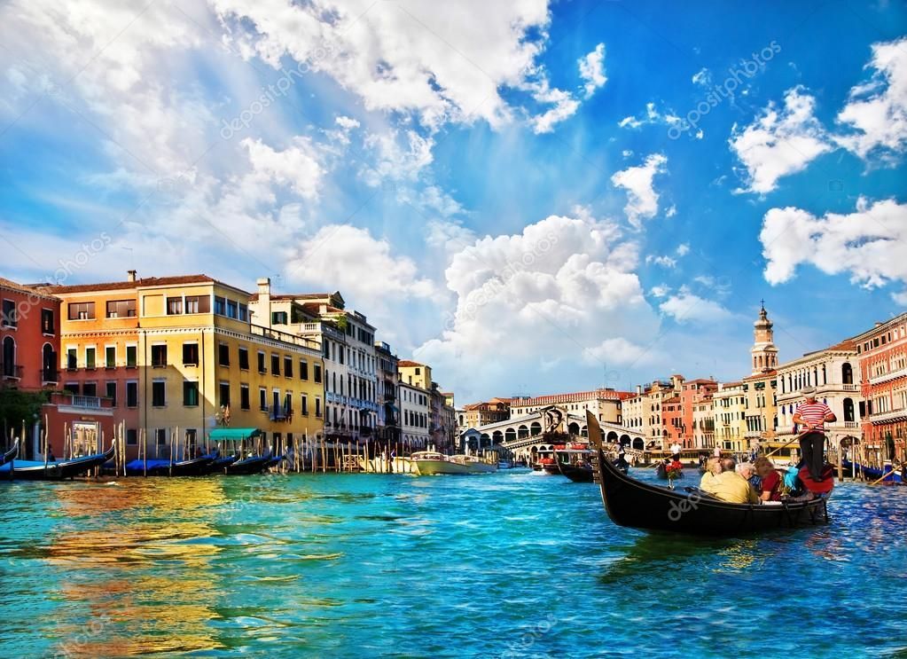 A group of people are riding a gondola down a river in venice.