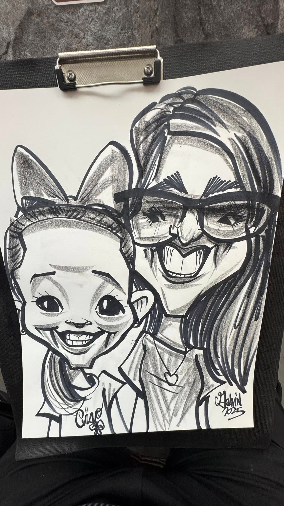 Black-and-white cartoon portrait of two smiling people, one with cat ears and one wearing glasses, on a clipboard