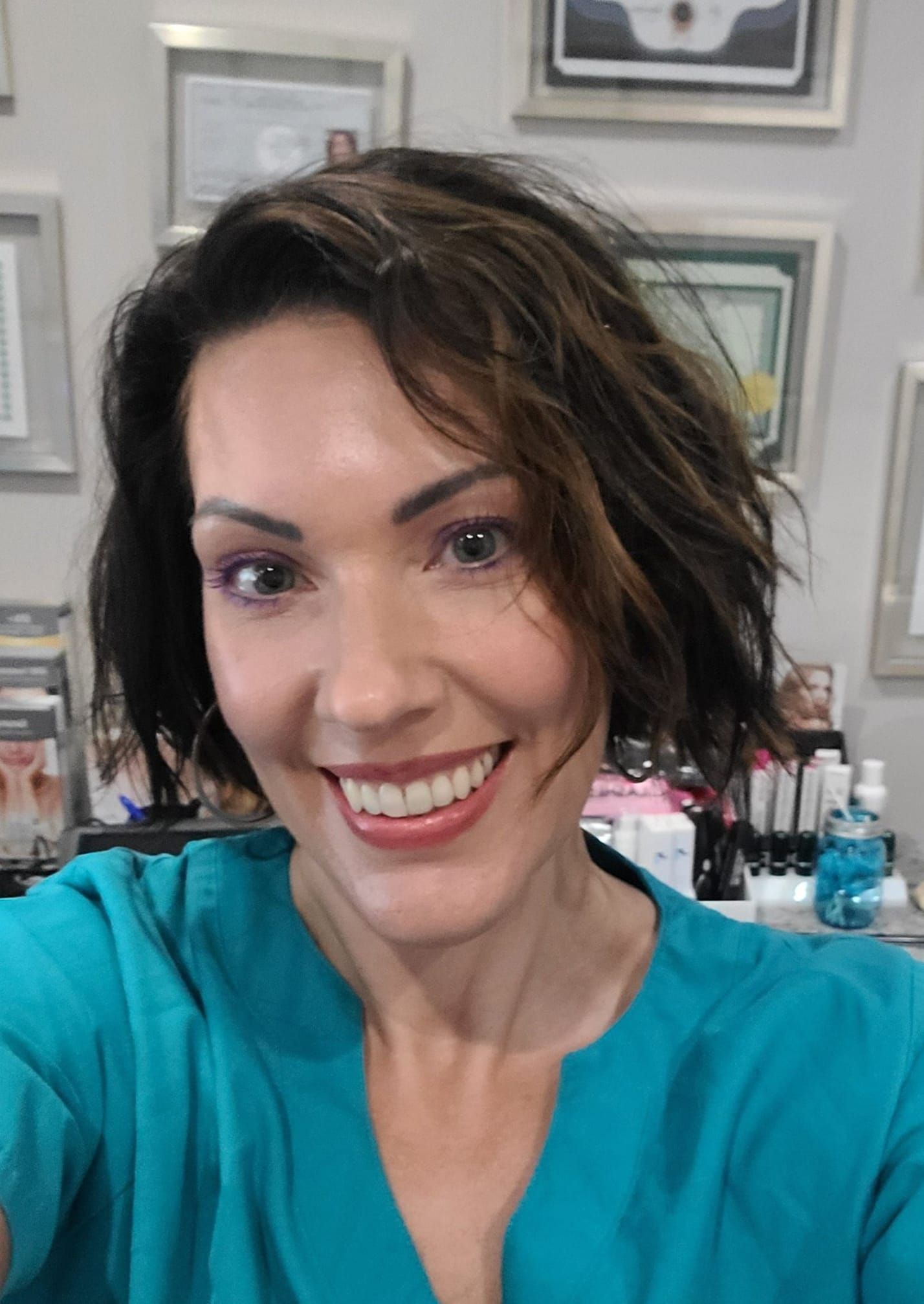 A woman in a blue shirt is smiling for the camera