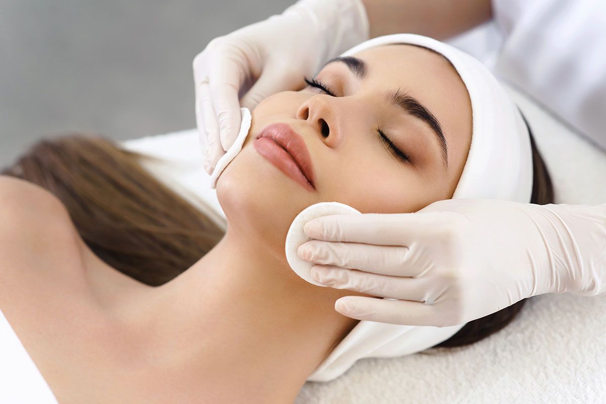 A woman is getting a facial treatment at a beauty salon.