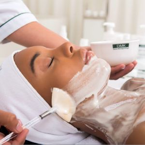 A woman is getting a facial treatment at a spa.