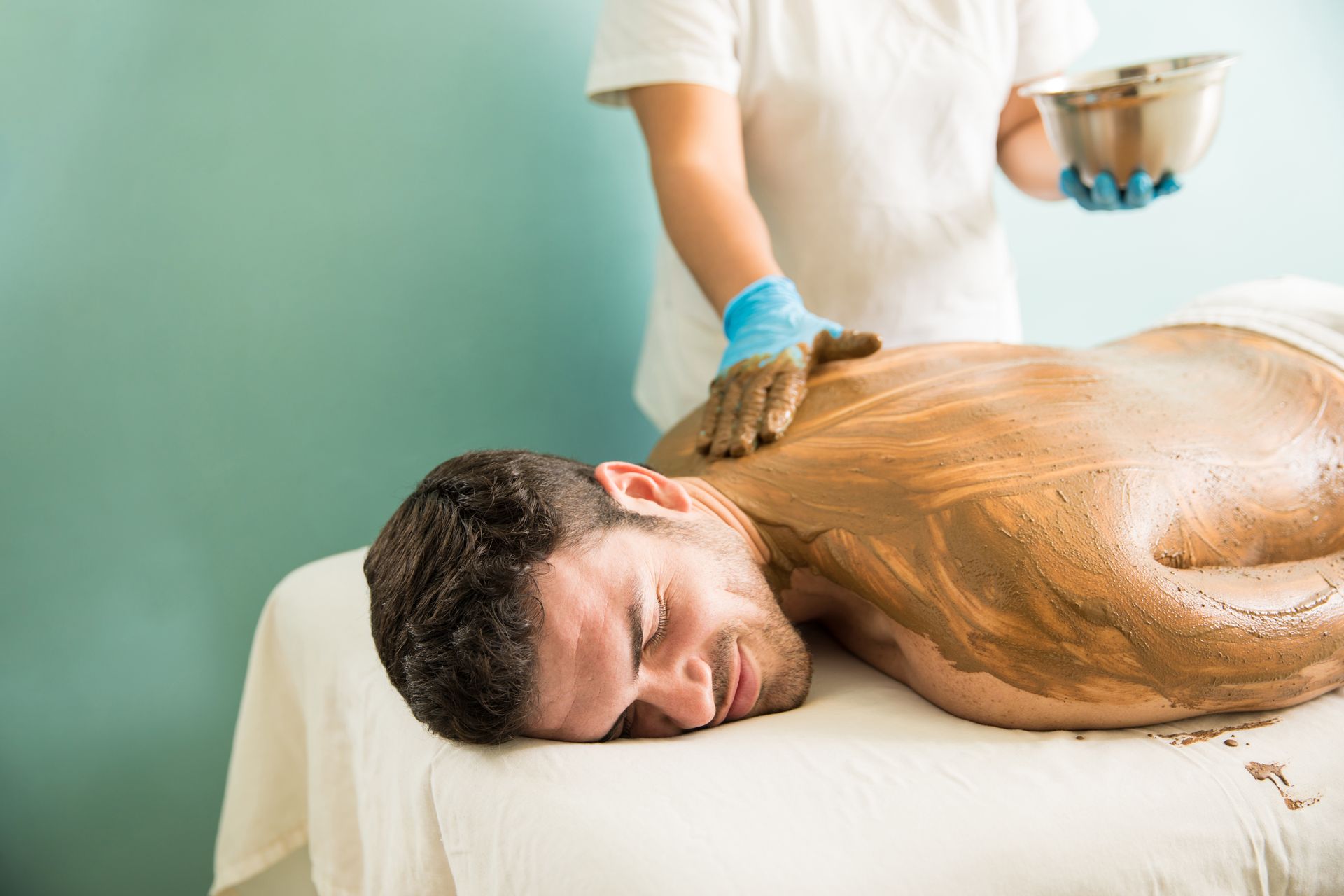 A man is getting a chocolate massage at a spa.