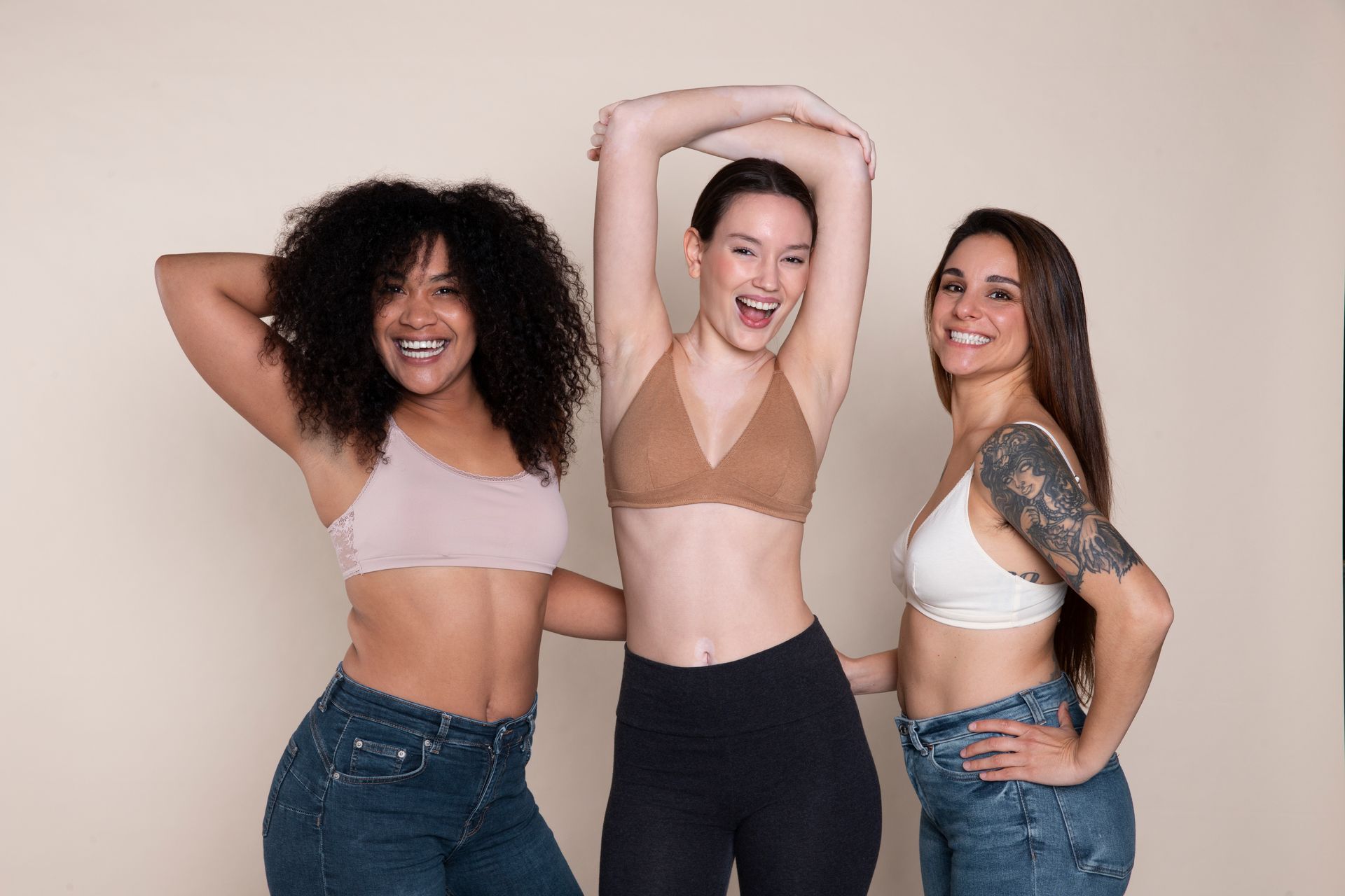 Three women in bras are posing for a picture together.