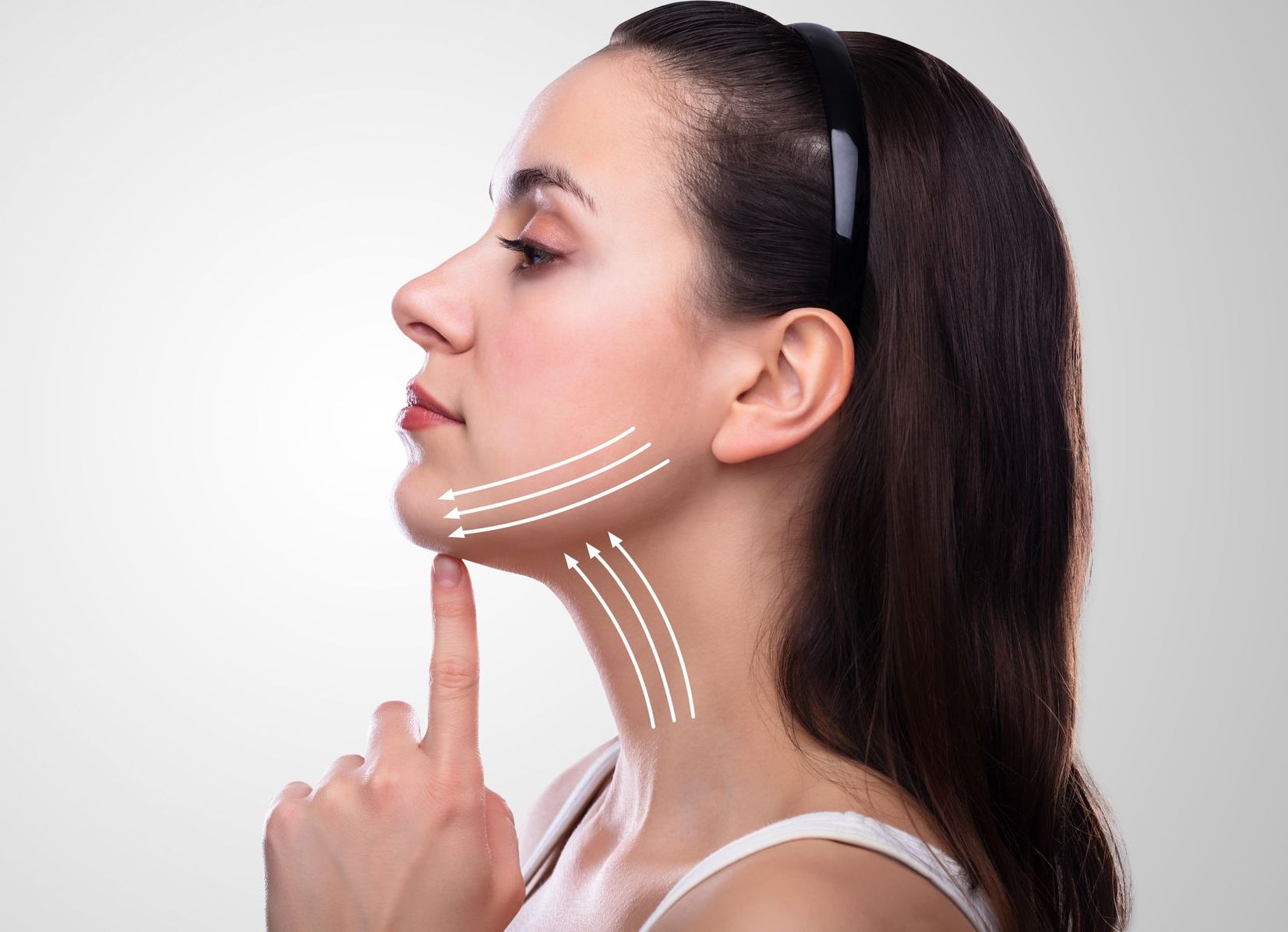 A woman is pointing at her neck with lines drawn on it.