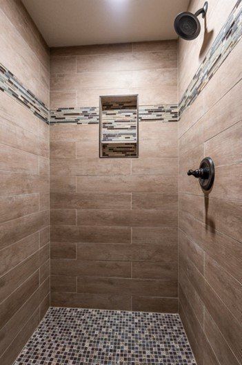 A shower with wooden tiles and a mosaic floor