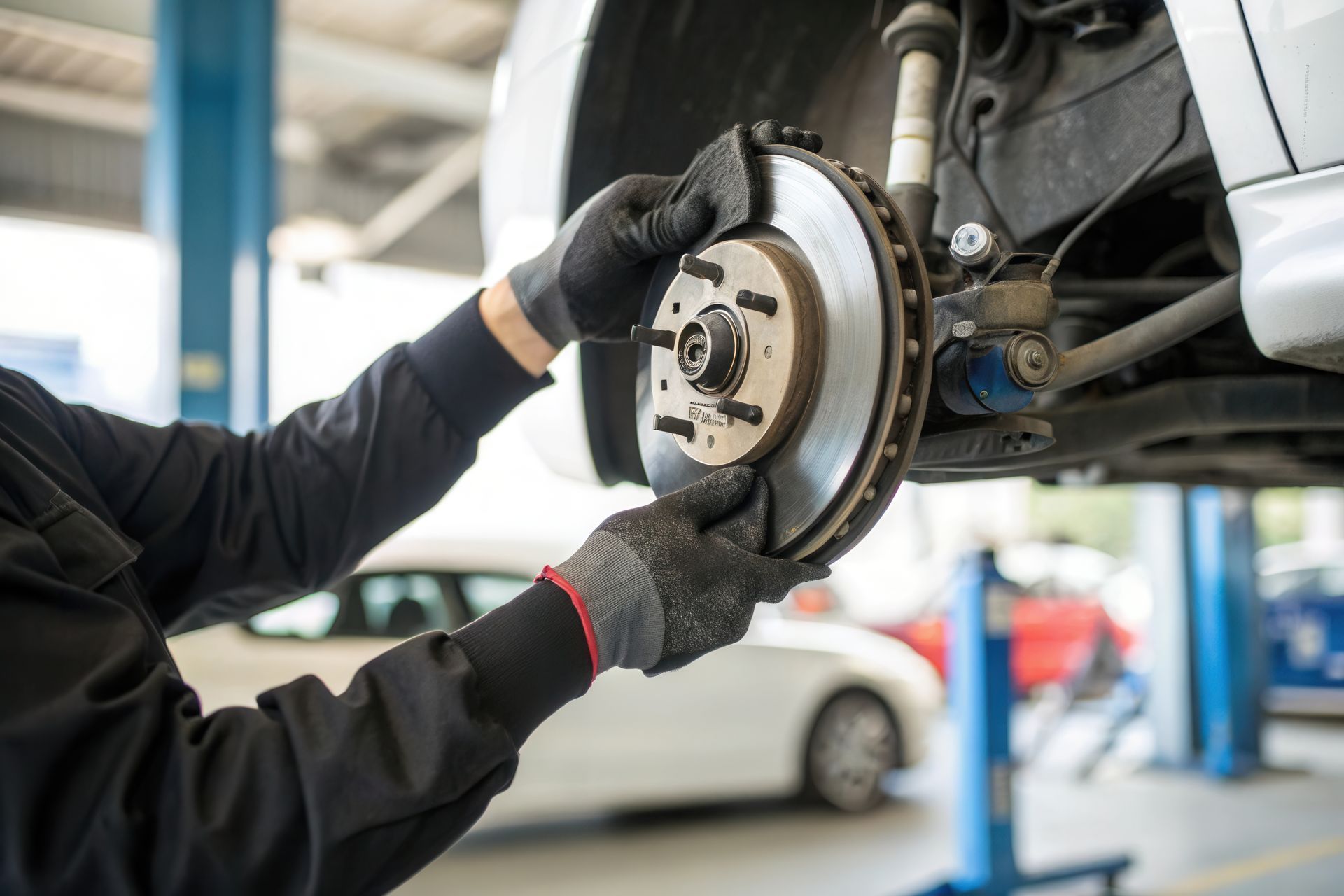 A mechanic performing auto brake repair on a car in a garage, ensuring safety and performance. A mechanic performing auto brake repair on a car in a garage, ensuring safety and performance.