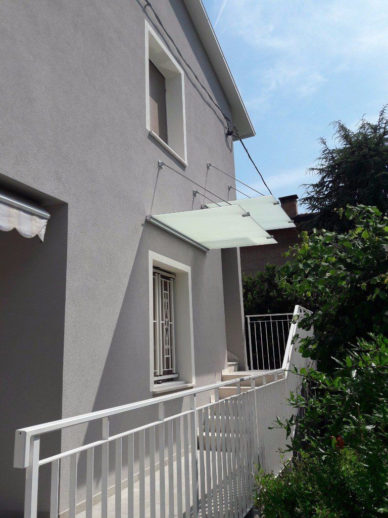 doppia pensilina sopra una finestra e delle scale in balcone