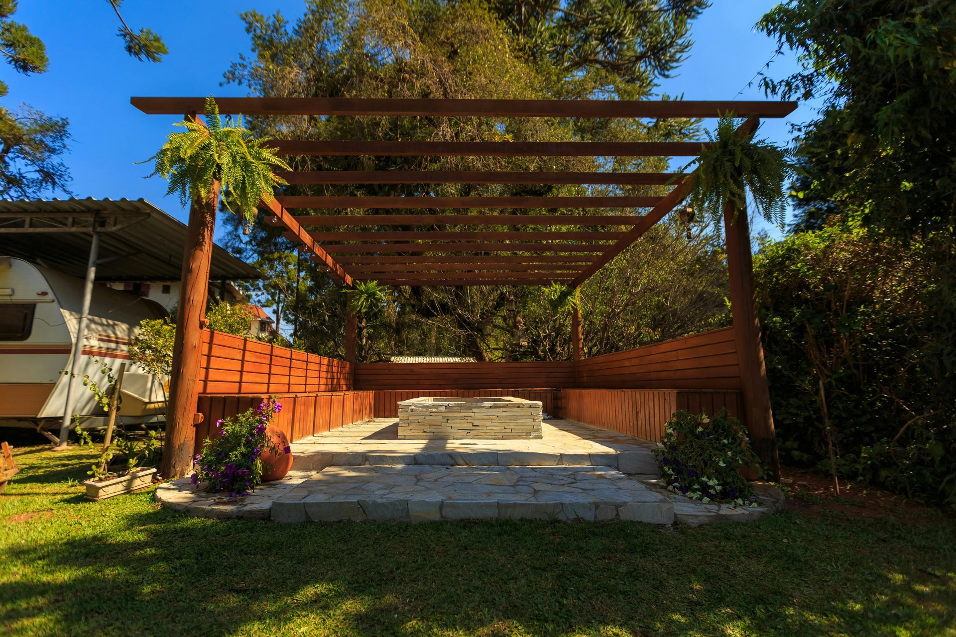 Two men are working on a wooden deck next to a pool.
