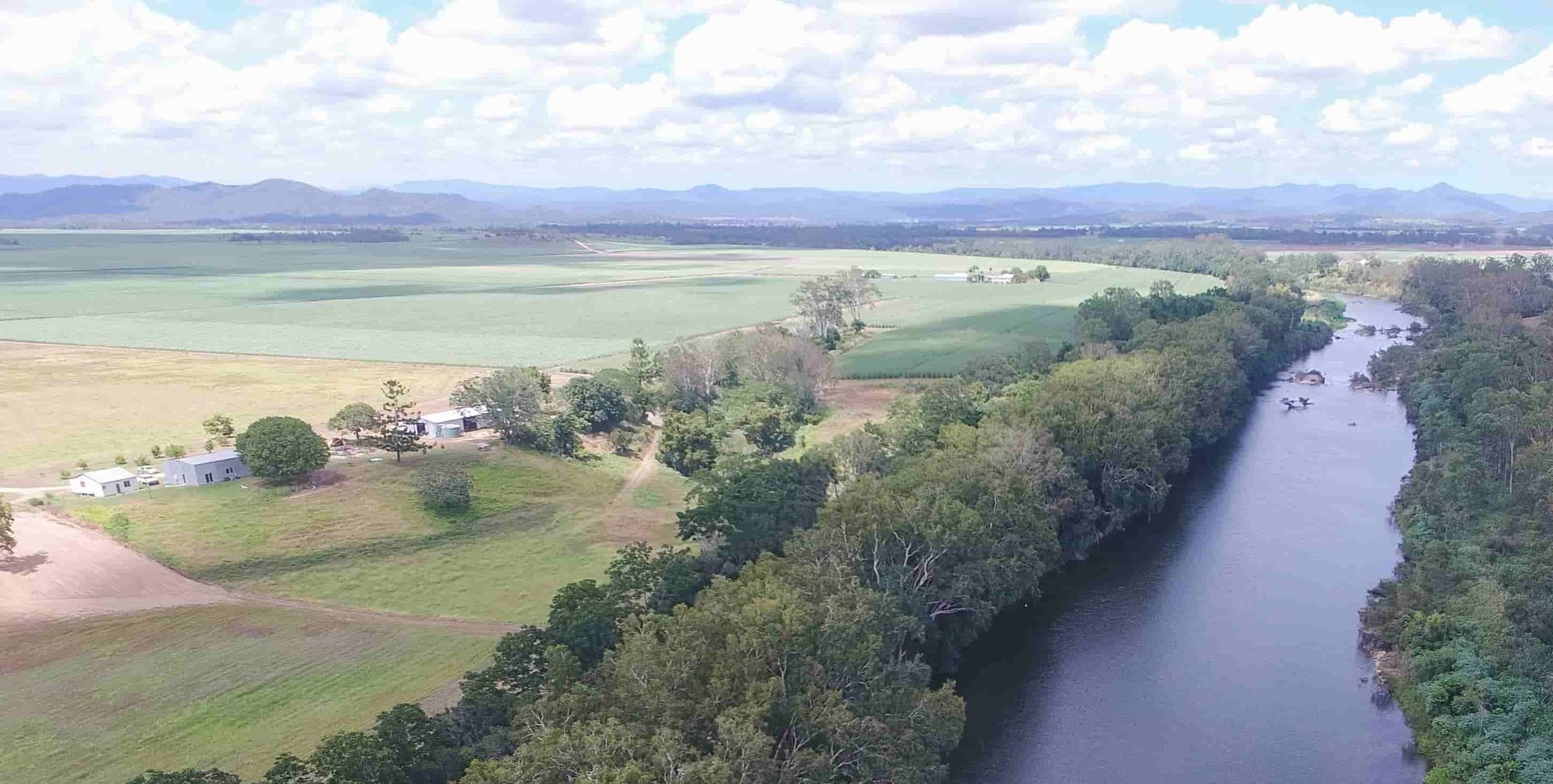 An aerial view of a river surrounded by trees and grass — Active Tree Fellas in Howard, QLD