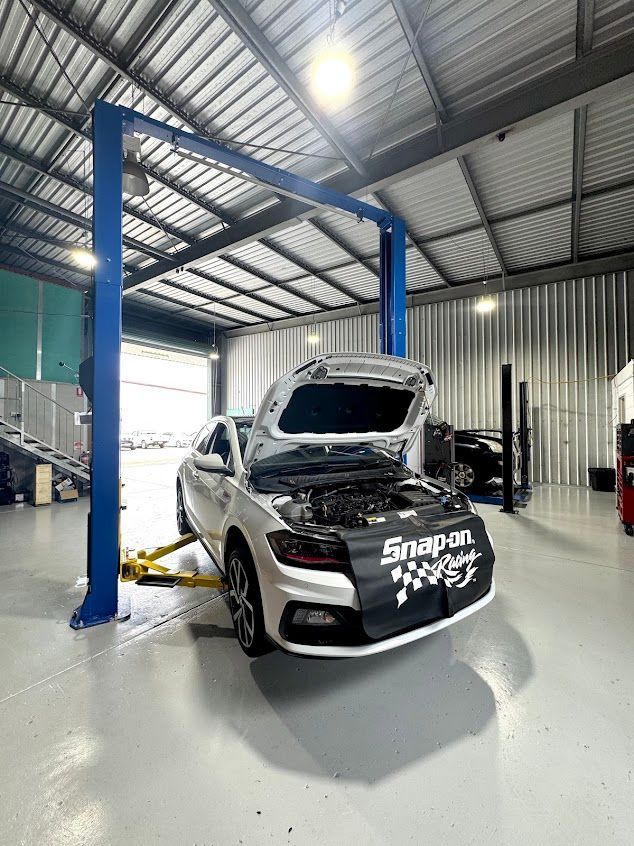 A Car is Sitting on a Lift in a Garage With the Hood Up — Axton Automotive Services in Kunda Park, QLD