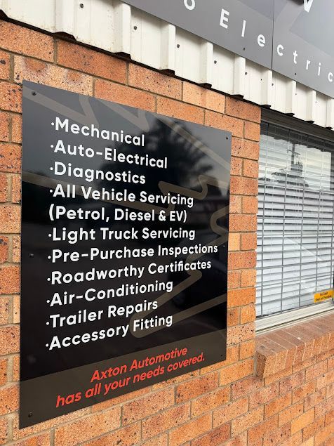 A Sign on a Brick Wall Says That Axton Automotive Has All Your Needs Covered  — Axton Automotive Services in Kunda Park, QLD