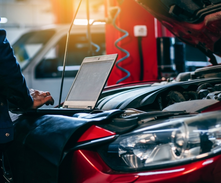 Mechanic On Computer Under the Hood of a Car — Axton Automotive Services in Kunda Park, QLD