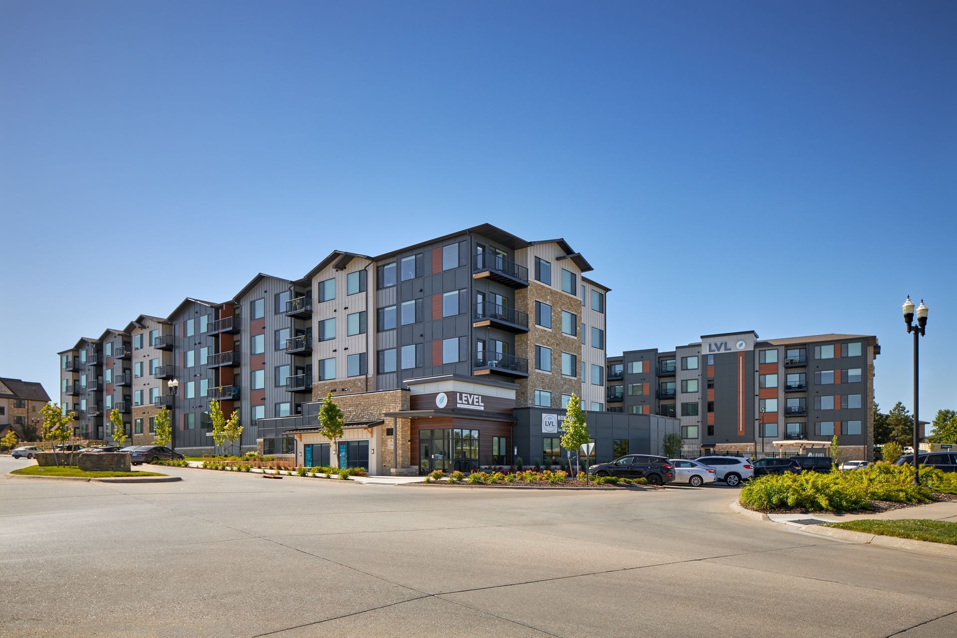 A large apartment building with a parking lot in front of it.