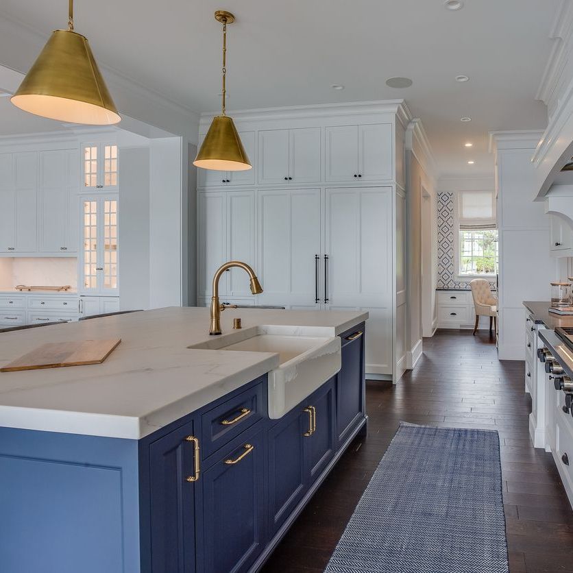 A kitchen with blue cabinets and white counter tops