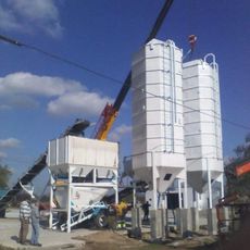 Un montón de silos amarillos están encima de una pila de tierra.