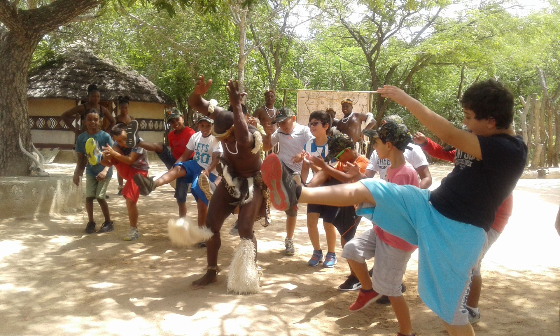 A group of people are dancing in a park and one of them is wearing a shirt with the number 20 on it