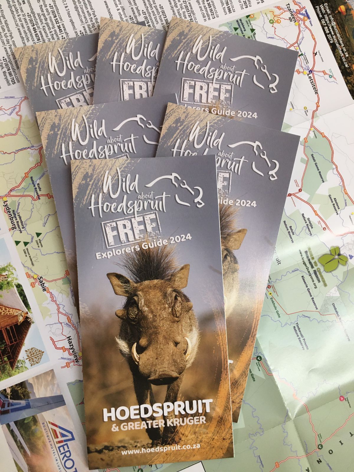 A bunch of brochures with a picture of a warthog on them are sitting on top of a map.