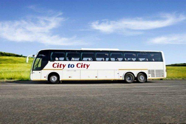 a city to city bus is parked on the side of the road