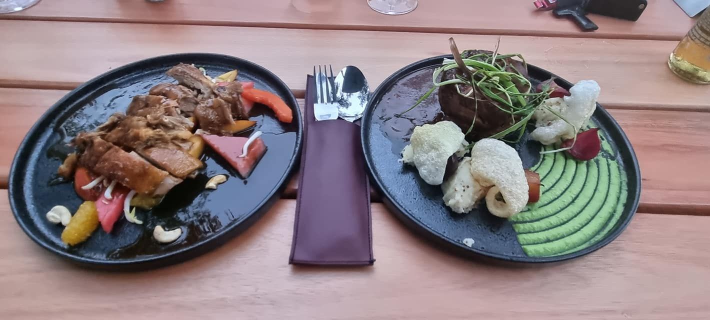 two plates of food are on a wooden table