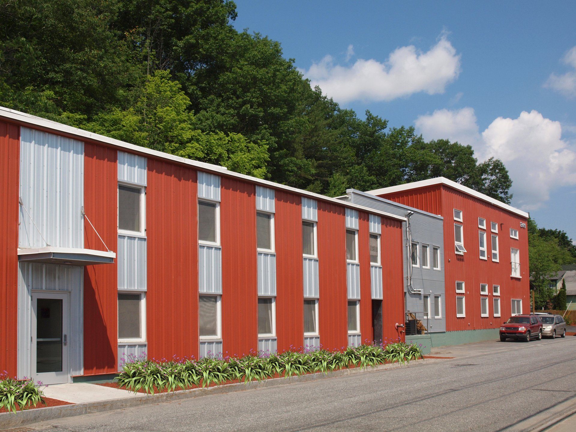 A red and white building with a car parked in front of it