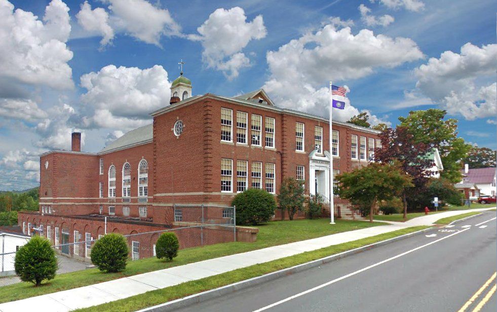 A large brick building sits on the side of a road