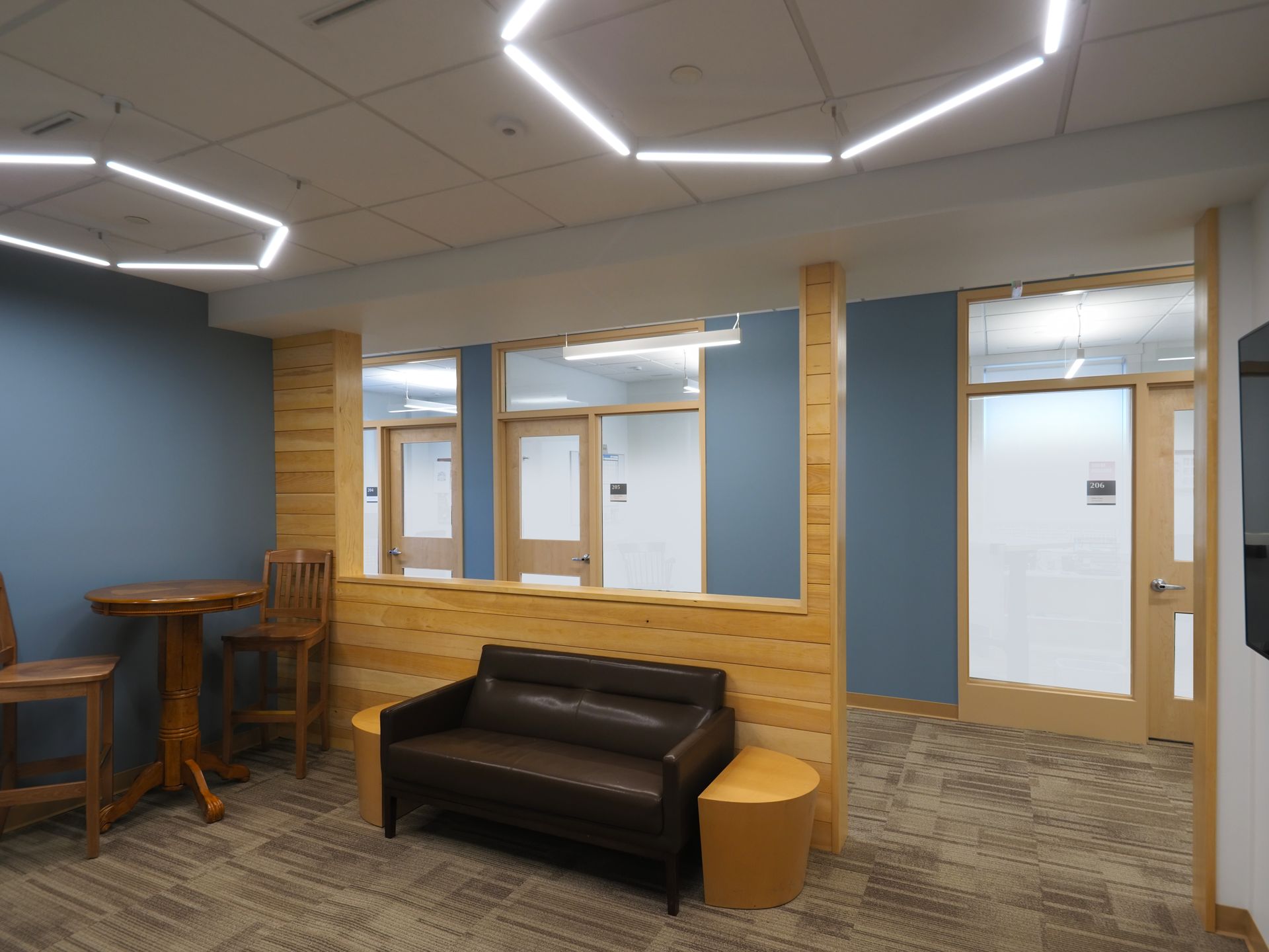 A waiting room with a couch , table and chairs