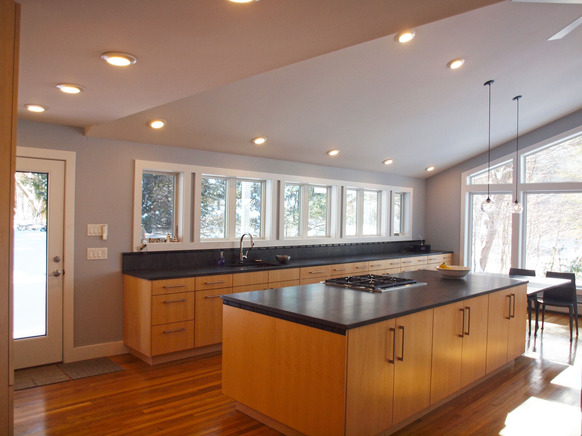 A kitchen with a large island and lots of windows