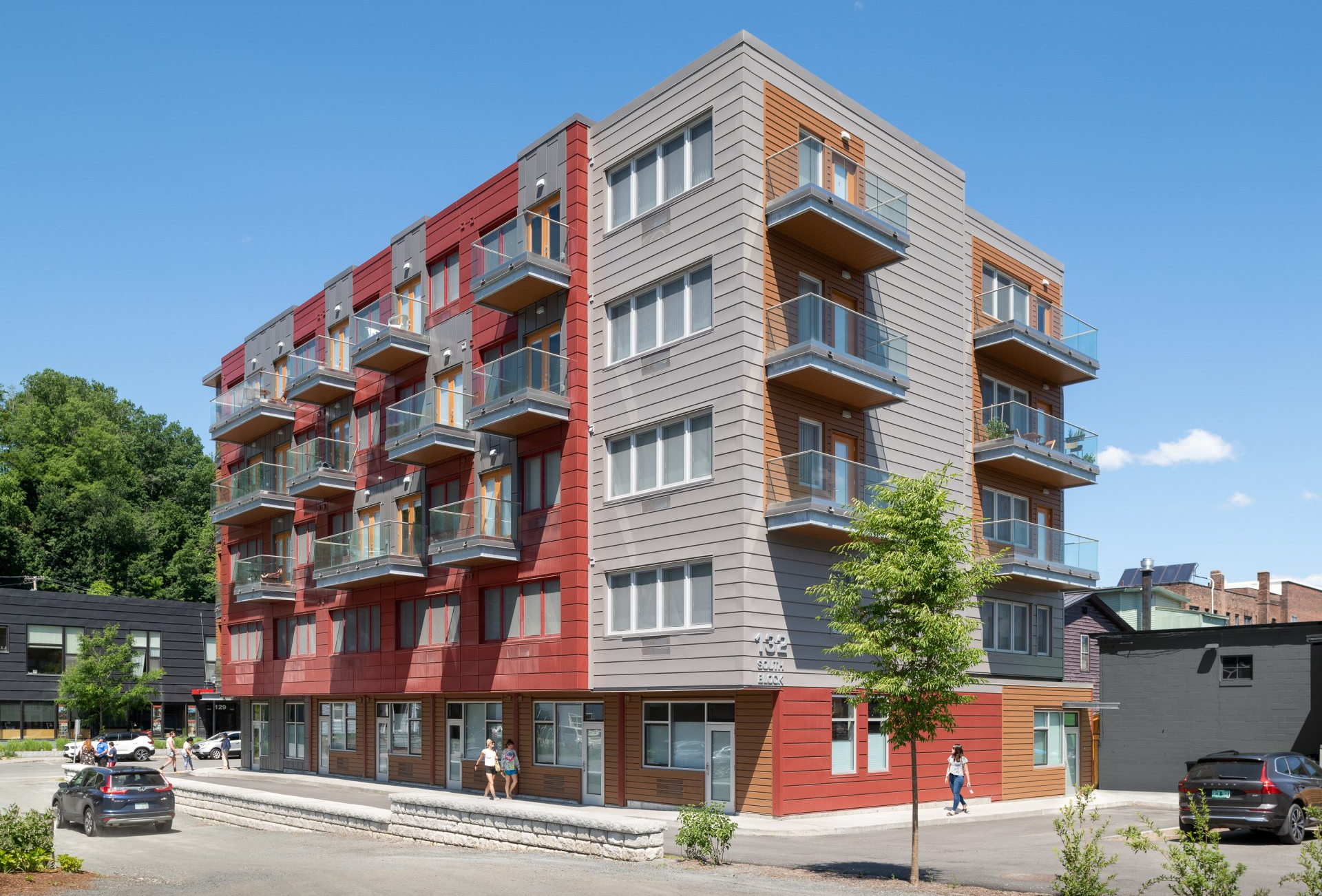 A large apartment building with cars parked in front of it