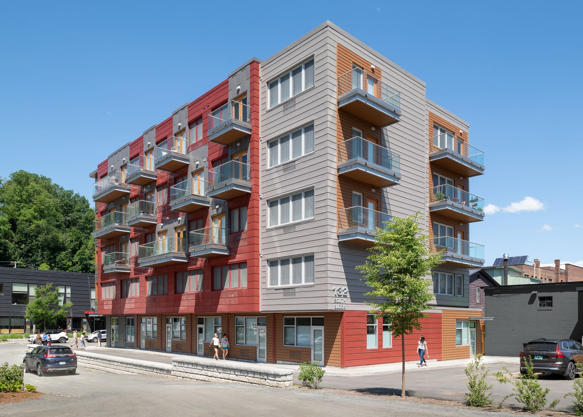 A large apartment building with cars parked in front of it
