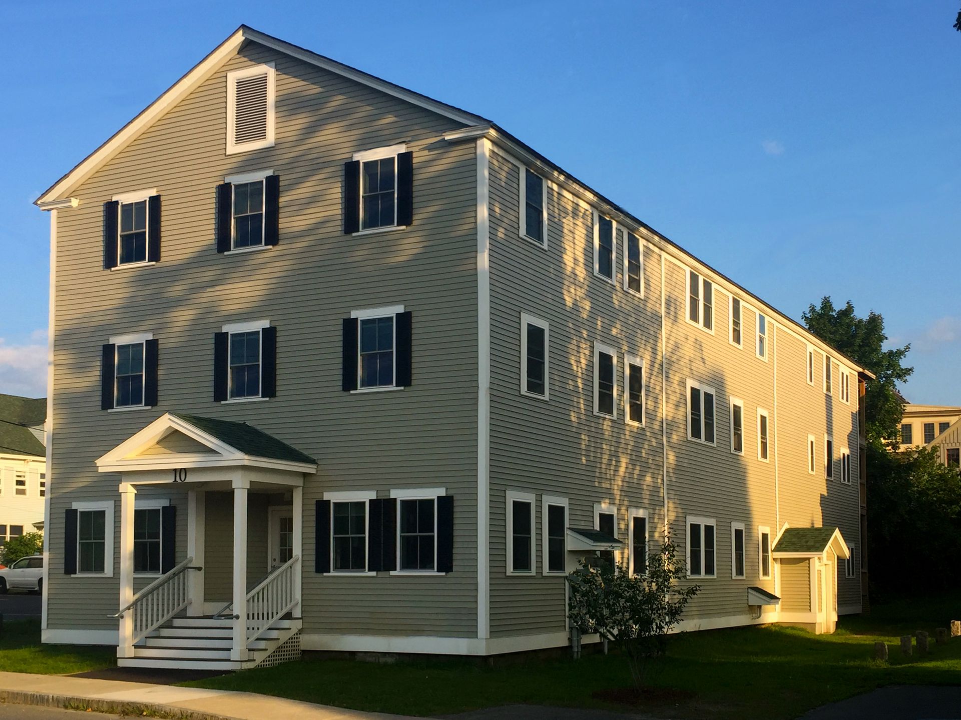 A large apartment building with a porch and stairs
