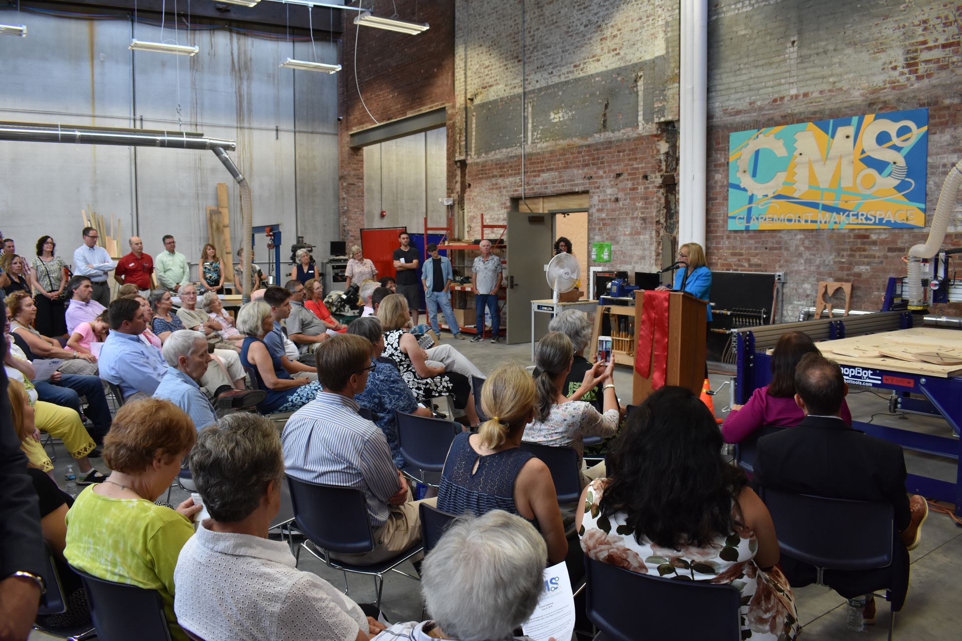A large group of people are sitting in chairs in a room.