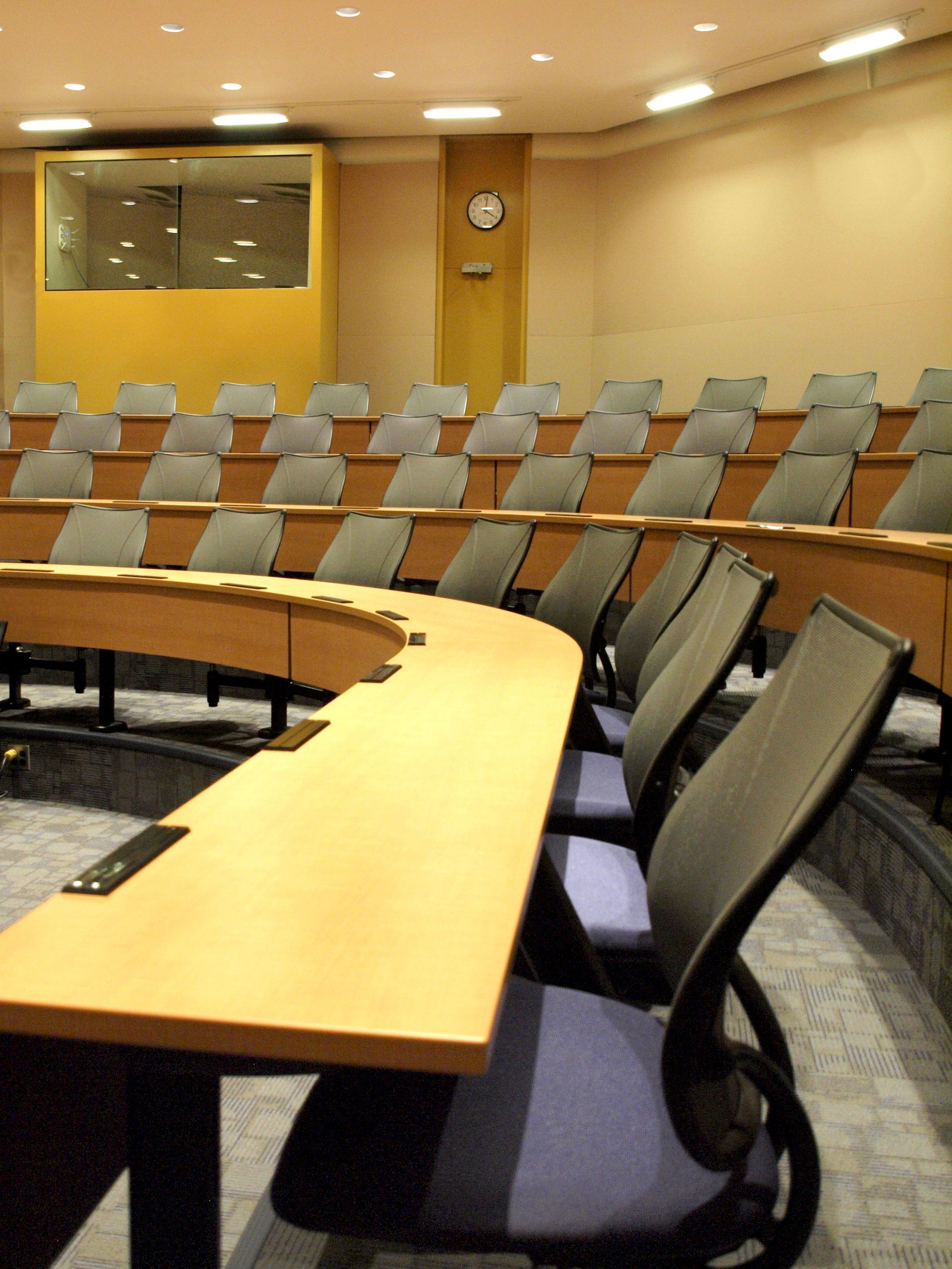 A conference room with tables and chairs and a clock on the wall